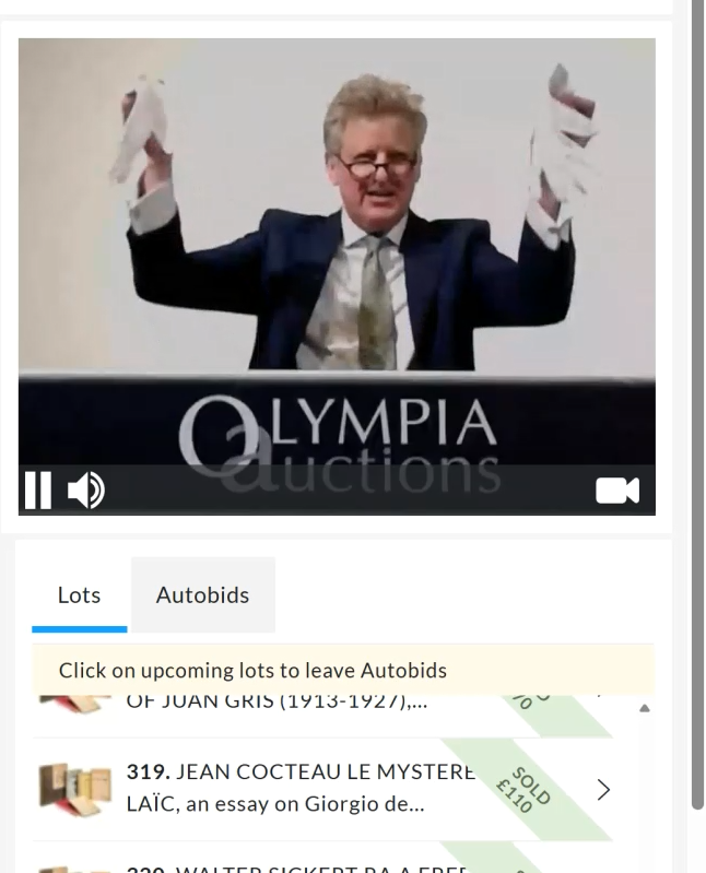 Auctioneer Adrian Biddell holding up a pair of white gloves