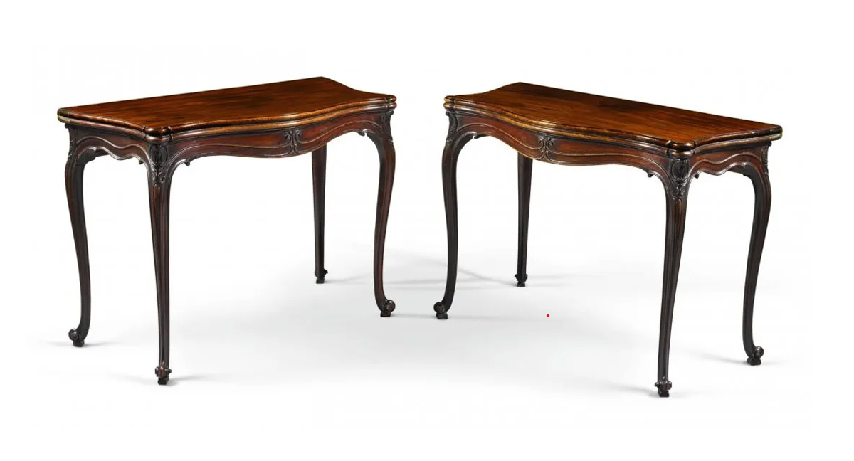 A pair of George III carved mahogany serpentine fold-over tables.